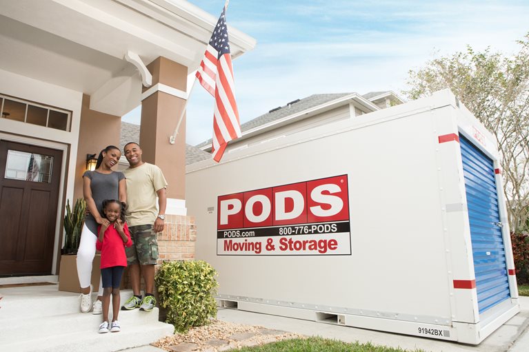 A military family in front of house and PODS container