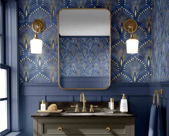 A newly remodeled bathroom featuring a chic mirror and vanity set with bold blue and gold wallpaper on the walls.