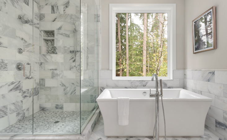 A primary bathroom after it’s been remodeled to include a large soaker tub and a walk-in shower.