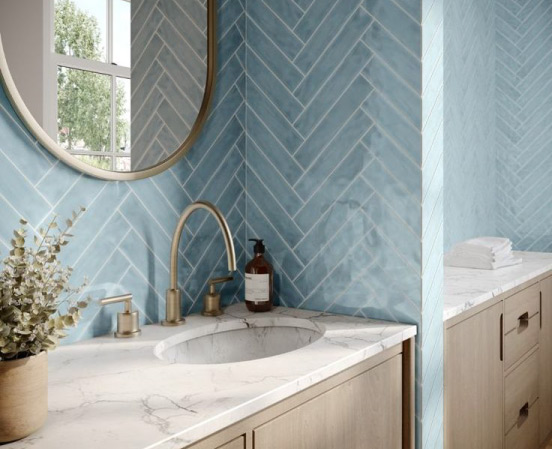 A newly renovated bathroom with polished ceramic subway wall tiles arranged in a herringbone pattern on the walls.
