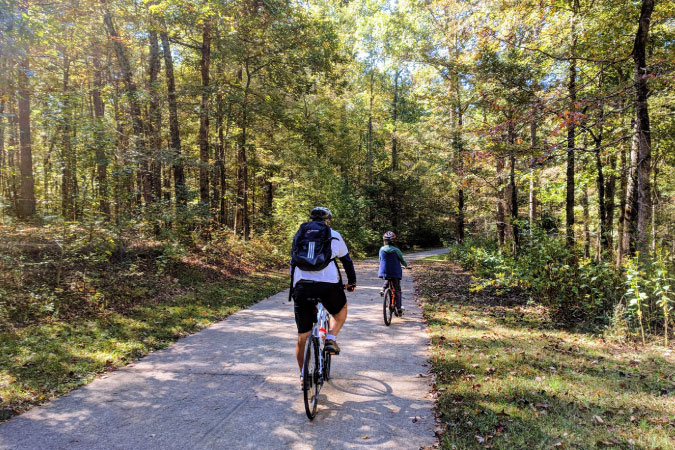 Two bicyclists enjoy a sunny afternoon biking on a wooded trail in Atlanta, Georgia