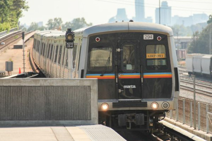 A MARTA train is traveling toward the airport in Atlanta, Georgia, on a sunny day