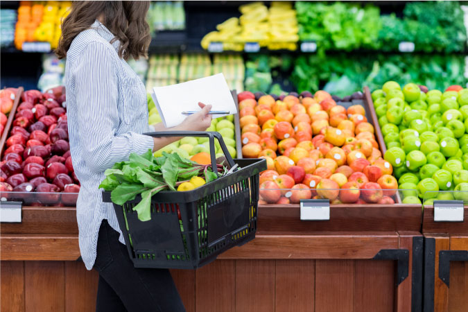 A woman is filling her grocery basket with fresh fruits and veggies at a grocery store in Cleveland, Ohio.