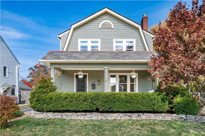 A beautiful, two-story home in Columbus, Ohio, featuring a covered porch and neatly pruned hedges