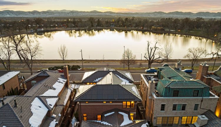 Beautiful homes in Denver’s Washington Park neighborhood surround the quaint Smith Lake, featuring distant mountain views. 