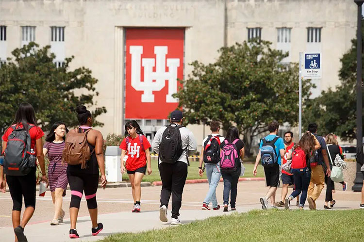 Students walk through the campus of University of Houston on a bright summer day