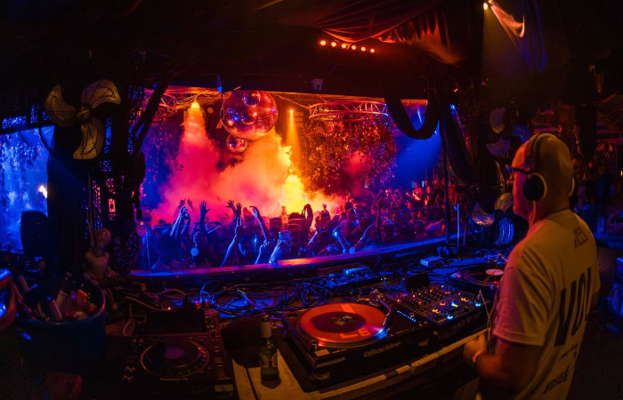 A DJ mixes music as the crowd in Club Space goes wild during a night out in Miami.