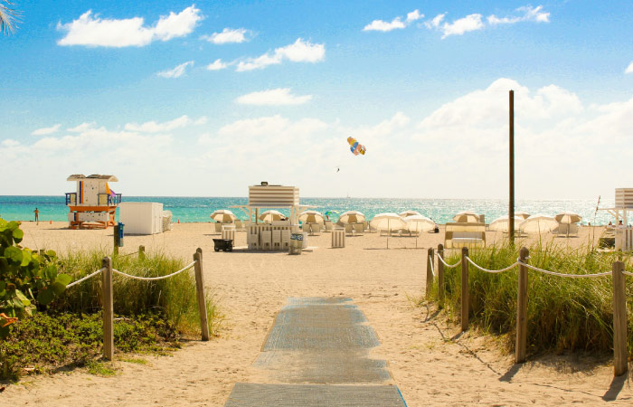  Umbrellas and beach chairs are set out on South Beach in Miami on a beautiful sunny day.