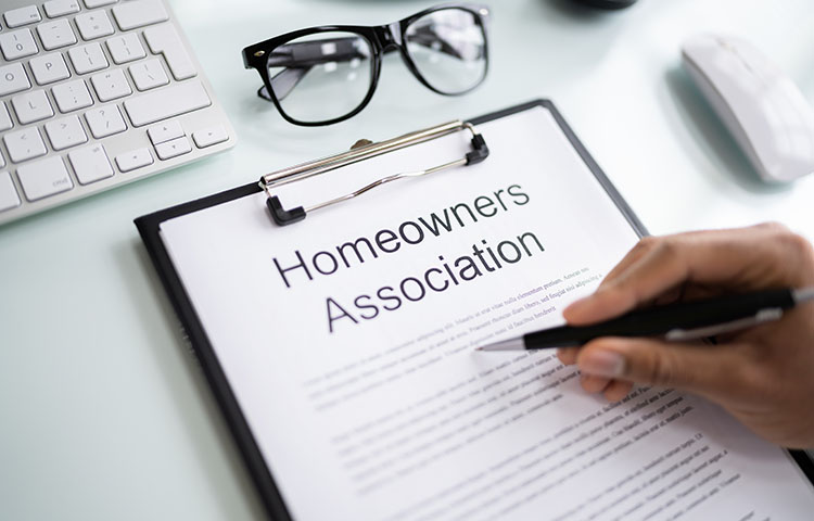 A sheet of paper with “Homeowners Association” as the title. Someone is reviewing what is written with a pen