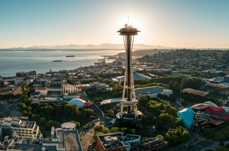 Aerial view of the Space Needle and surrounding areas in Seattle, Washington, during sunrise.