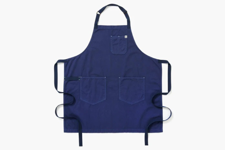 A blue Hedley & Bennett apron is laid out flat against a white background.