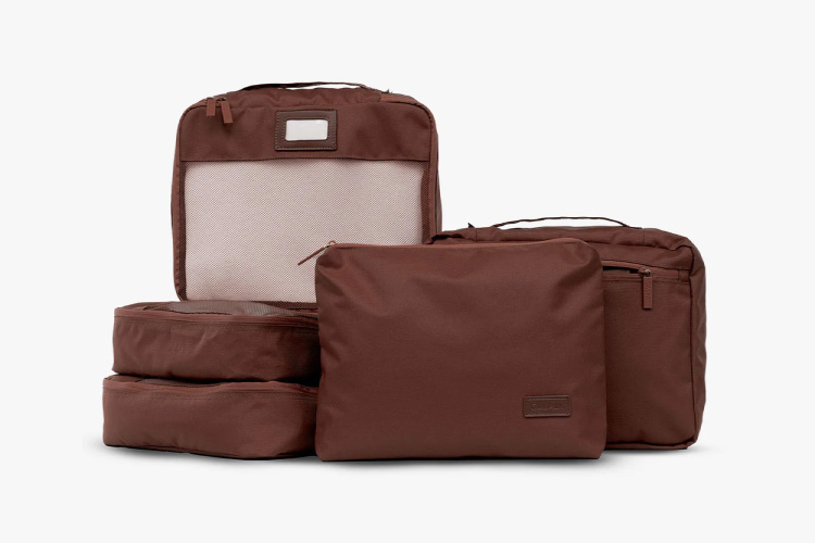 A set of five packing cubes from CALPAK in a burgundy color. 