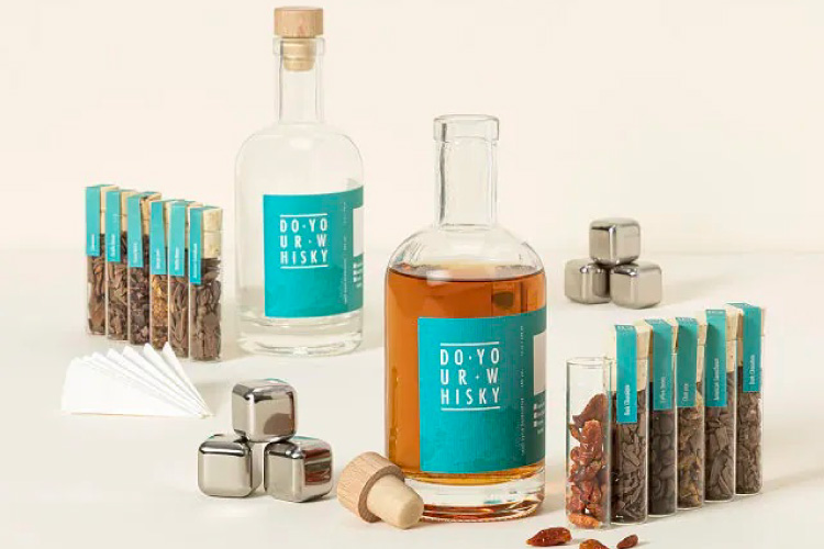 A Whiskey-Making Kit from Uncommon Goods, featuring metal ice cubes, wood chips, and botanicals. 