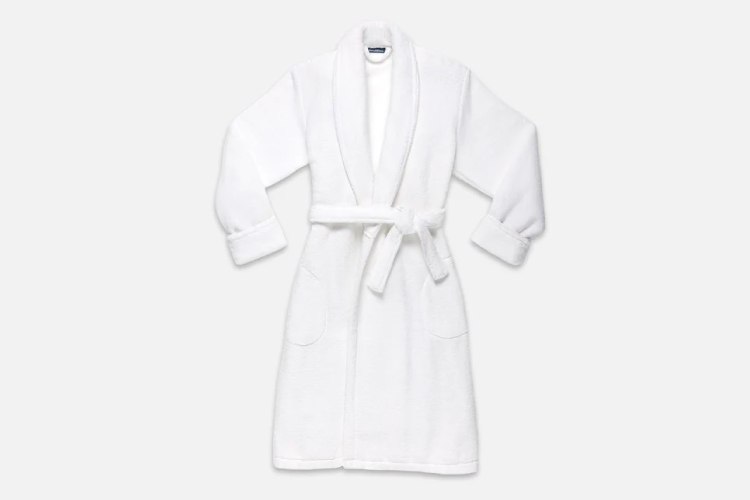 A plush white robe from Brooklinen is set against a white background.