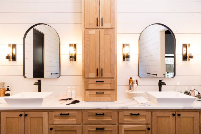 A beautiful double vanity with custom wooden cabinets and individual mirrors