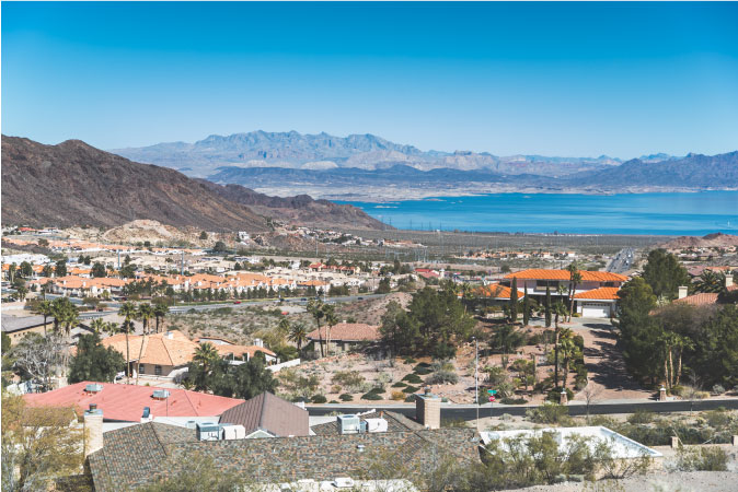 Aerial view of Boulder City, Nevada — one of the best Las Vegas suburbs — featuring surrounding mountain ranges and Lake Mead