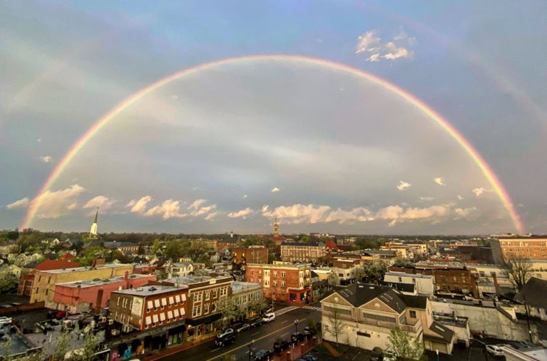 The city of Montclair, New Jersey. There is a double rainbow covering the entire city skyline.