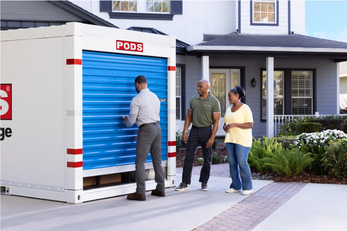 A man is closing the door to a PODS portable moving container after helping his senior parents load the container for their move to North Carolina.