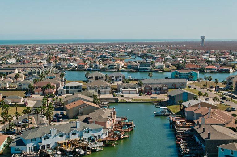 Aerial view of a waterfront neighborhood on Padre Island — one of the best Corpus Christi neighborhoods.