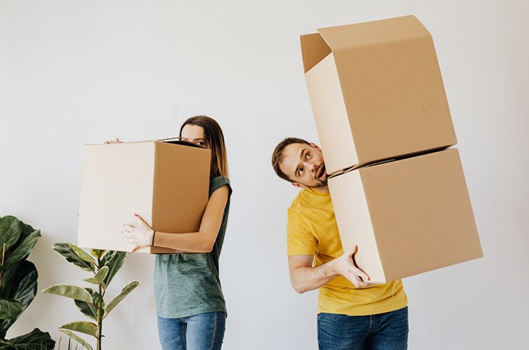 A couple carrying full boxes packed for their move