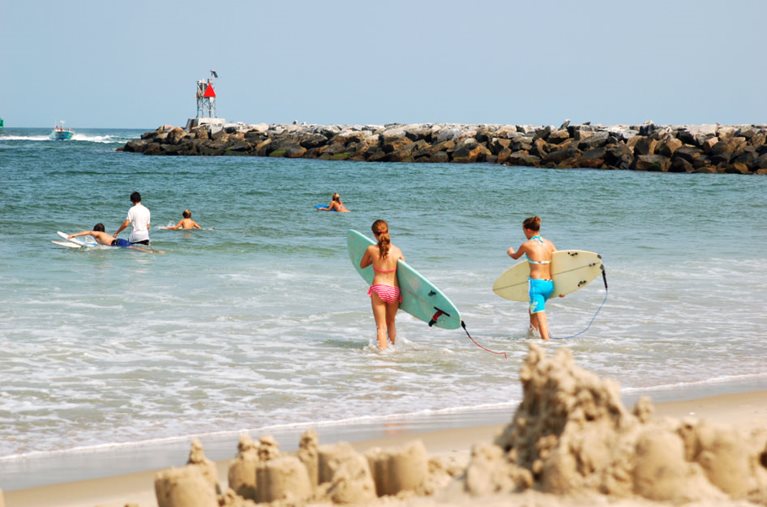 Half a dozen locals head out to surf on a sunny day in Virginia Beach