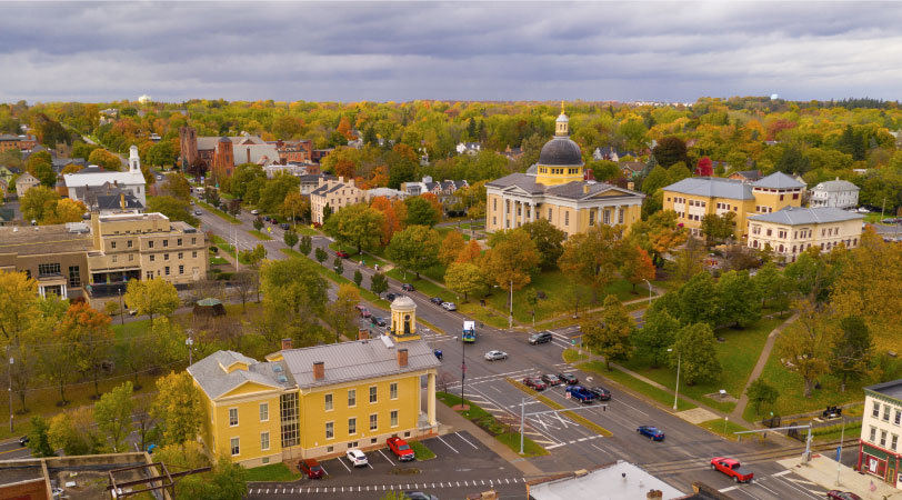 Aerial view of Rochester Street in downtown Canandaigua, New York. The Ontario County Courthouse can be seen on the right side of the image. It’s the end of summer. The leaves on the trees are mostly green, but are starting to change colors.