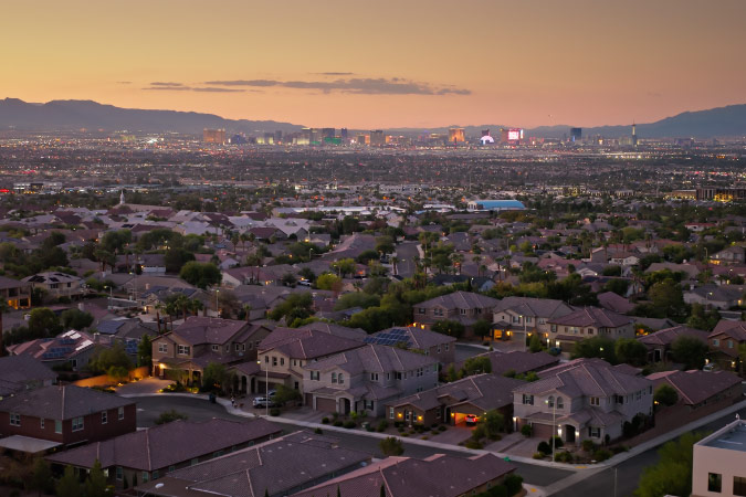 Aerial view of Henderson, Nevada, at sunset with the mountains and Las Vegas Strip visible in the distance