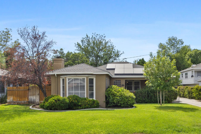 Streetside view of a one-story, single-family home in Oleander — one of the best Bakersfield neighborhoods — featuring solar panels on the roof and a landscaped front lawn.