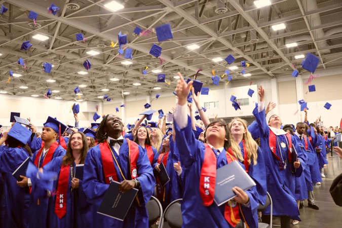 Members of a graduating class from one of Virginia Beach’s public schools toss their graduation caps high in the air at the close of the graduation ceremony