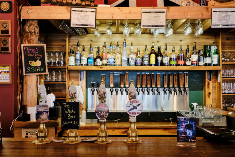 View of the bar at Santiam Brewing Co. in Salem, Oregon, featuring an array of beers on tap as well as a variety of spirits above the bar.