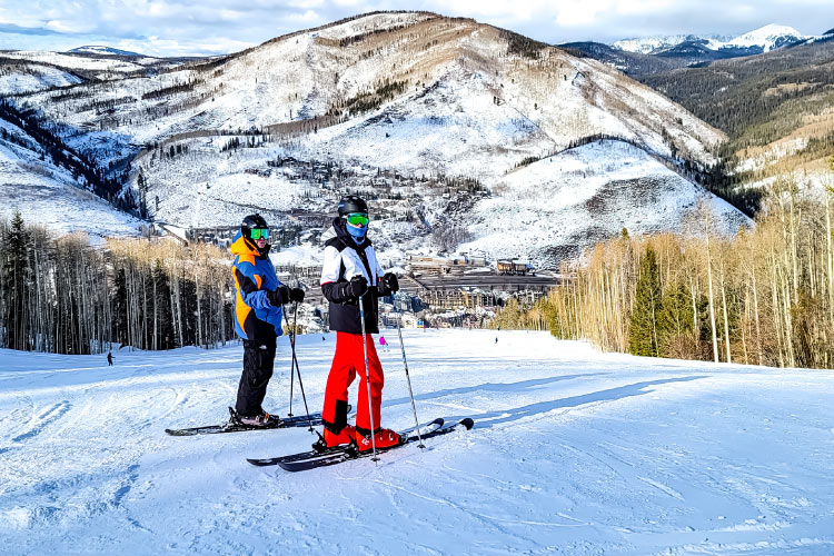 A retired couple, dressed in full ski gear, poses for a photo on Vail Mountain in Vail, Colorado. 