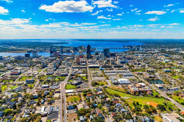Aerial view of Downtown Jacksonville, Florida, on a bright day. The river can be seen just past the downtown buildings. 