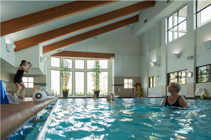 Several resident retirees are taking part in a water aerobics class at Friendship Village of Bloomington