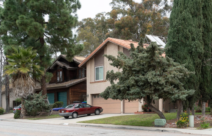 Distinct residential homes are partially obscured by mature trees in the Scripps Ranch neighborhood of San Diego. 