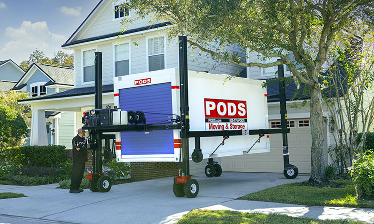 A PODS driver is using PODZILLA to position a PODS portable moving container in a residential driveway so that it can be used for moving to one of the best Salt Lake City neighborhoods.