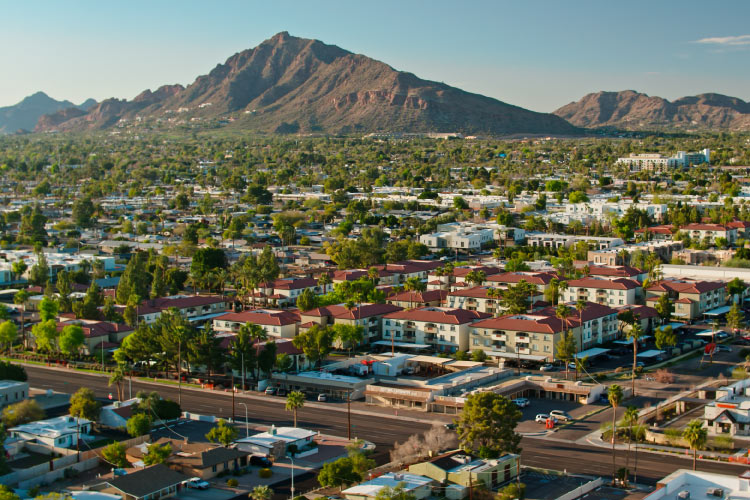 Aerial view of residential neighborhoods in Scottsdale, Arizona — one of the best places for retiring in Arizona — with the mountains filling the skyline in the distance.
