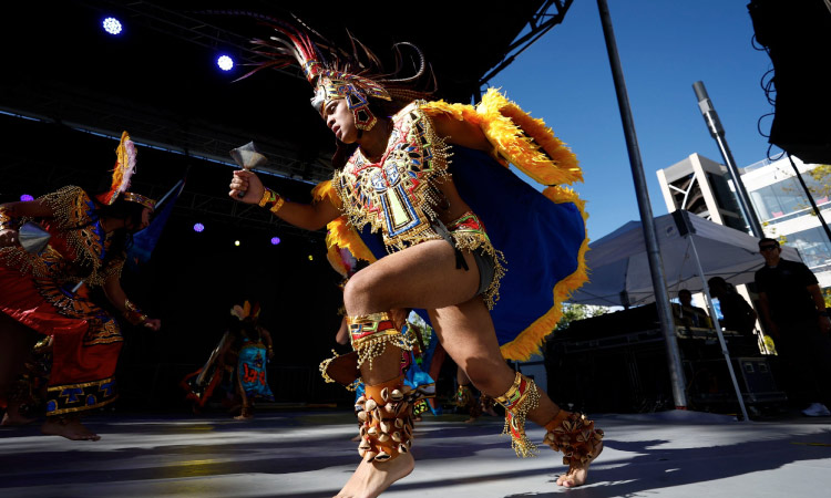 Traditional native dancers adorned in vibrant costumes perform a captivating dance on stage at the Utah Arts Festival in Salt Lake City, Utah. The dancer's expressive movements and cultural attire bring a dynamic and enriching experience to the festival.