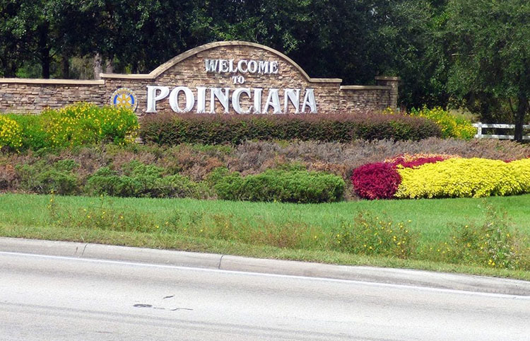 A sign in front of the Poinciana community, reading “Welcome to Poinciana.”