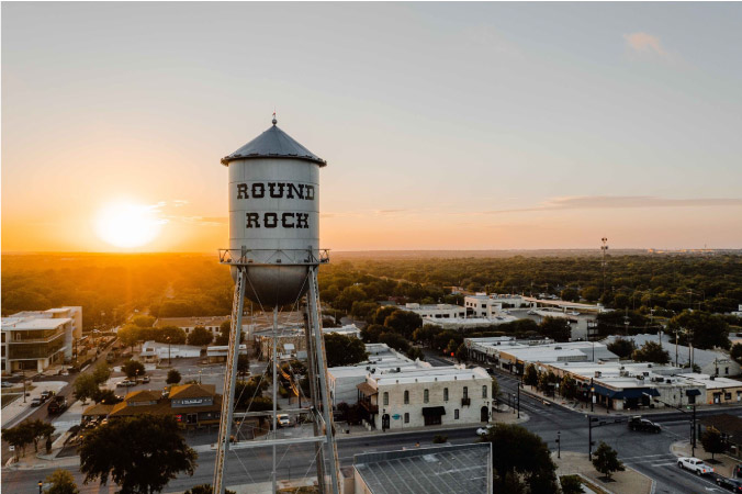 View of the water tower in Round Rock, Texas, as the sun is setting in the background.