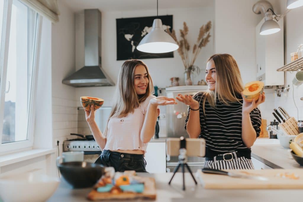 Two Gen Z females filming a cooking video in a kitchen