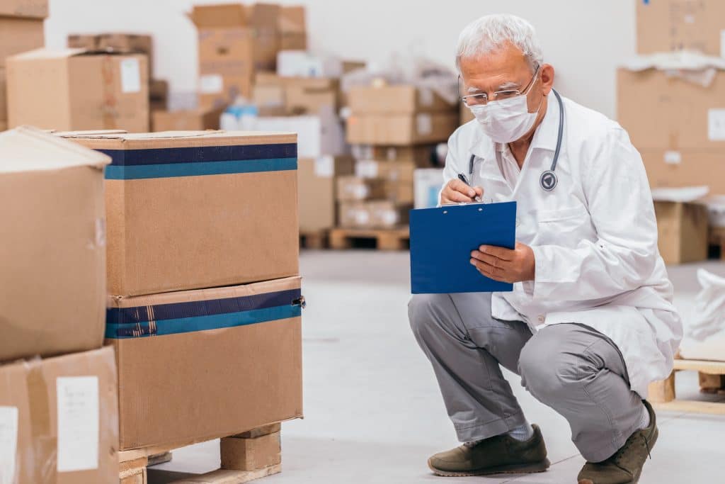 Doctor reviewing stock in a warehouse for inventory management