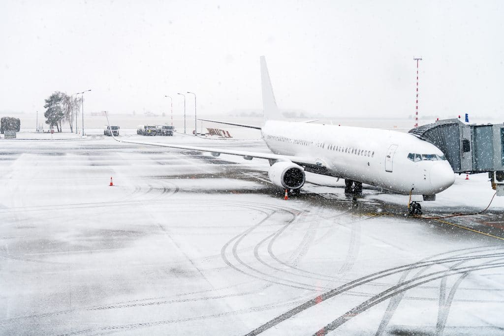An airplane loading passengers outside in snow